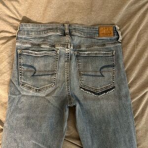 American Eagle Light wash medium rise Jegging with holes, asymmetrical pockets